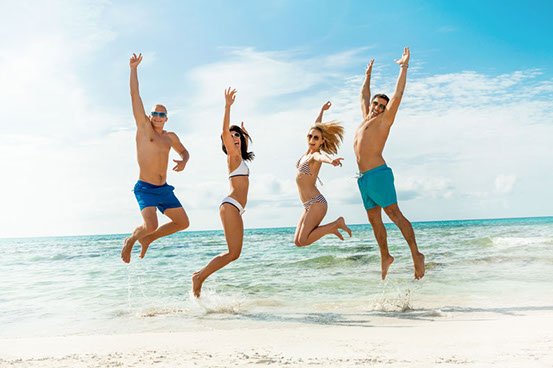 4 Leute springen vor Freude am Strand